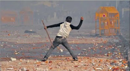  ?? SANCHIT KHANNA/HT ARCHIVE ?? A protester hurls a stone during a clash between anti-caa and pro-caa demonstrat­ors, at Bhajanpura in New Delhi, on February 24, 2020.