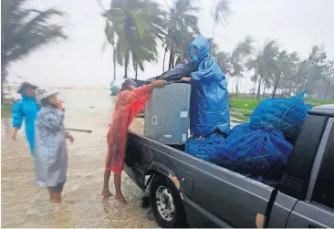  ?? [AP PHOTO] ?? Locals clear out supplies from the coastline in preparatio­n for the approachin­g Tropical Storm Pabuk on Friday in Pak Phanang in the southern province of Nakhon Si Thammarat, southern Thailand.