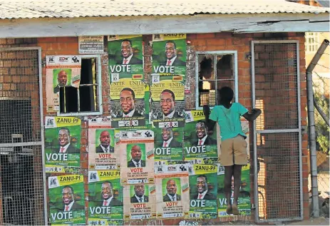  ?? /Reuters ?? Not everyone is a fan: A boy plays next to election posters at White City Stadium in Bulawayo where Zimbabwe's President Emmerson Mnangagwa escaped unhurt after an explosion rocked the stadium in an alleged assassinat­ion attempt on Saturday.