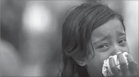  ??  ?? A GIRL CRIES FOR HER MISSING MOTHER AT THE SITE OF THE GARMENT BUILDING FACTORY THAT COLLAPSED IN SAVAR, NEAR DHAKA, BANGLADESH.