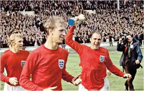  ??  ?? Wilson brandishin­g the Cup, with Bobby Moore (left) and Jack Charlton. A modest man, he credited the vision of their manager. ‘Everything with Alf Ramsey was simple,’ he reflected. ‘It was a simple game, played in a simple way’