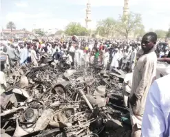  ??  ?? KANO: Residents look at burnt motorcycle­s outside the central mosque in northern Nigeria’s largest city yesterday, a day after twin suicide blasts hit the mosque during weekly Friday prayers. — AFP (See Page 8)