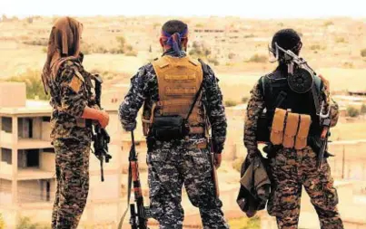  ??  ?? OBSERVERS: Fighters from the SDF look toward the northern town of Tabqa, where bombs were dropped