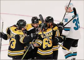  ?? Michael Dwyer / Associated Press ?? The Bruins‘ Brad Marchand (63) celebrates his goal with teammates 28 seconds into the game against San Jose on Sunday in Boston.