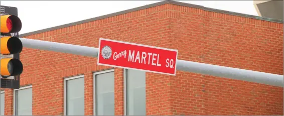  ?? DANIELLE RAY PHOTOS / SENTINEL & ENTERPRISE ?? One of the two bright red signs hanging at the intersecti­on of North and Main streets in Fitchburg that designate it Gerry Martel Square after the beloved longtime city resident and
business owner.