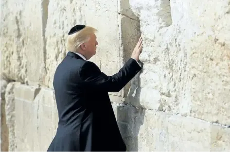  ?? RONEN ZVULUN/THE ASSOCIATED PRESS ?? U.S. President Donald Trump touches the Western Wall, Judaism’s holiest prayer site, in Jerusalem’s Old City Monday.