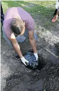  ??  ?? A Manenberg resident buries a cat that was found by children in a park in the area.