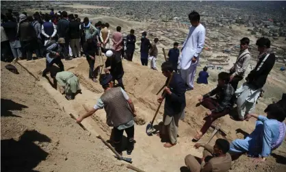  ?? Photograph: Xinhua/ REX/Shuttersto­ck ?? People dig graves for the dozens of victims, mainly schoolgirl­s, of bomb blasts in Kabul, Afghanista­n, on Saturday.