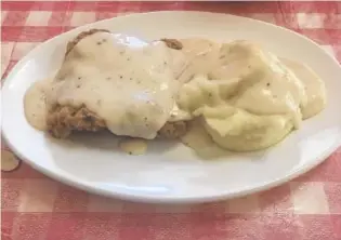  ?? PHOTO BY GILBERT STRODE ?? Country-fried steak and mashed potatoes are smothered in a rich, peppery white gravy at Ellie’s Catfish Cafe.