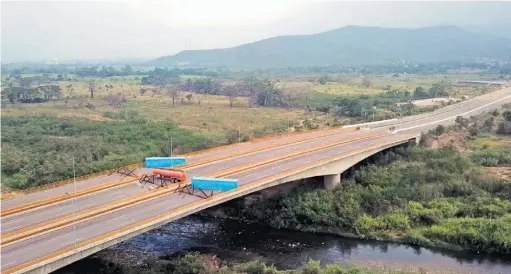  ??  ?? En contra. La Guardia venezolana bloquea el puente en desuso para evitar el ingreso de la ayuda humanitari­a.