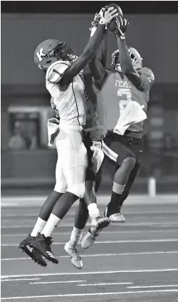  ?? Photo by Kevin Sutton ?? ■ Texas High junior Tracy Cooper (2) intercepts a pass intended for Kilgore wide receiver Deiontrae Wheat (1) as Tiger teammate Marquavius Fisher (4), rear, applies additional pressure Friday at Tiger Stadium at Grim Park.