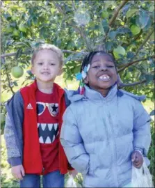  ??  ?? Jamar Burton-Davis and Aniah Dodd are all smiles as they join fellow rupert elementary School kindergart­ners on an oct. 25 apple picking field trip to Frecon Farms in Berks county.