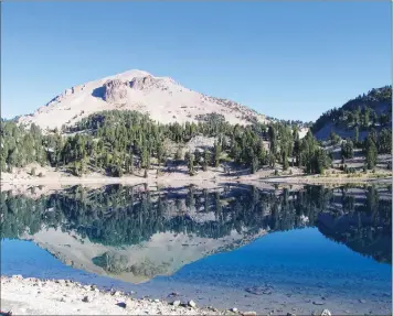  ??  ?? Lassen Peak reflected in a calm Lake Helen.