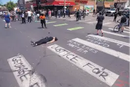  ?? JIM MONE/ASSOCIATED PRESS ?? A woman lies in the street as protesters gather Wednesday near the site of the arrest of George Floyd who died in police custody Monday in Minneapoli­s.