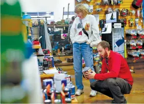  ??  ?? Manager Jeremy Parker, right, helps Mollie Rupp find a gift at the Northshore Rock/Creek store on Saturday.