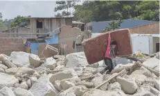  ?? — AFP ?? A young man carries a mattress amid the rubble left by mudslides caused by heavy rains in Mocoa, Putumayo department, southern Colombia.