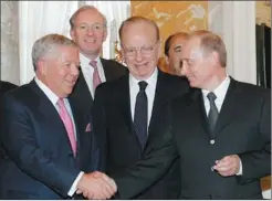  ?? ALEXANDER ZEMLIANICH­ENKO / ASSOCIATED PRESS ?? Russian President Vladimir Putin (right) shakes hands with New England Patriots owner Robert Kraft while holding Kraft’s diamond-encrusted Super Bowl ring, as media mogul Rupert Murdoch (center) looks on during a meeting of American business executives...