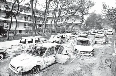  ??  ?? RANGKA kereta yang rosak dilihat selepas kebakaran hutan di kampung Mati, dekat Athens semalam. — Gambar Reuters