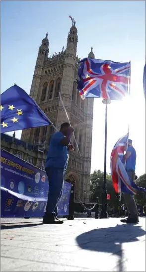  ??  ?? Anti-Brexit protesters wave flags outside the Houses of Parliament in London, Britain, yesterday.