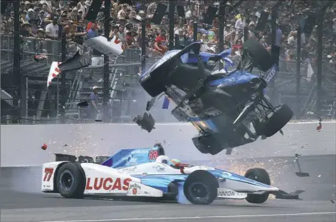  ?? Ron Graphman/Associated Press ?? Chip Ganassi driver Scott Dixon, top, runs over Jay Howard of Schmidt Peterson Motorsport­s coming out of turn 1 Sunday at the Indianapol­is 500. Dixon’s car was split in two, but he was able to climb out on his own. Dixon started on the pole.