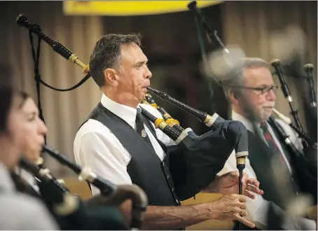  ?? DAX MELMER ?? Members of the Scottish Society of Windsor Pipe Band and the Windsor Police Pipe Band perform Amazing Grace on Saturday at the Scottish Club of Windsor as part of a worldwide tribute to the Manchester bombing victims at the Ariana Grande concert on May...