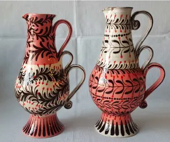  ??  ?? ABOVE Two recent garland jugs in pink. They are hand-thrown in chocolate earthenwar­e, then dipped in slip, hand-painted and finally finished with a transparen­t glaze.