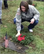  ?? SUBMITTED PHOTO ?? A volunteer dusts the tombstone of a World War II veteran after placing a wreath during the Wreaths Across America event at St. James Episcopal Church on Germantown Pike in Collegevil­le on Dec. 15.