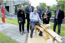  ?? CLIFFORD SKARSTEDT/EXAMINER ?? Peterborou­gh MPP Jeff Leal carves a canoe paddle after announcing $9 million in provincial funding to expand the Canadian Canoe Museum, next to general manager Carolyn Hyslop, Mayor Daryl Bennett, board of directors chairman John Ronson, Curve Lake...