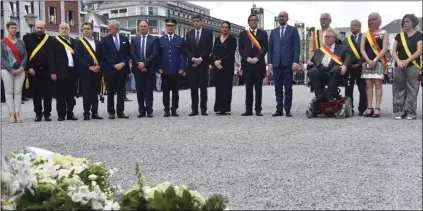  ??  ?? Belgian Prime Minister Charles Michel (center) stands with other officials, police and the general public during a moment of silence for shooting victims near the City Hall in Liege, Belgium, on Wednesday. A gunman killed three people, including two...