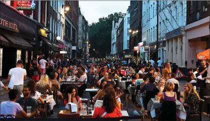  ??  ?? WHAT A TREAT: Alfresco dining in London’s Soho last summer. Restaurant­s say they will be even busier from April 12