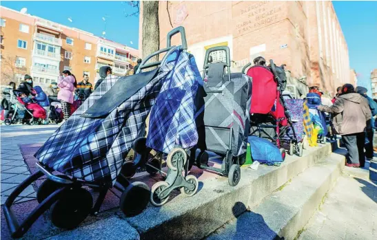  ?? EUROPA PRESS ?? Varias personas hacen cola para recibir alimentos de la Fundación Madrina en la plaza de San Amaro (Madrid)