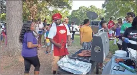  ??  ?? Amber Jackson talking to her husband, Roderick, as he mans the grill at Zion Hill Baptist Church in Rockmart last Sunday.