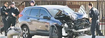  ?? — AFP photo ?? Law enforcemen­t personnel take a closer look at the destructio­n of an SUV involved in critically injuring nearly two dozen deputy recruits in a Los Angeles County Sheriff’s Department training academy class in Whittier, California.