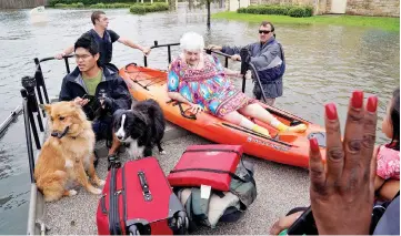  ??  ?? People and their pets are rescued from flood waters from Hurricane Harvey on a boat in Dickinson,Texas. — Reuters photo