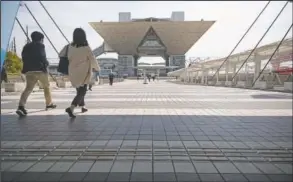  ?? (AP/Hiro Komae) ?? People walk towards the Tokyo Internatio­nal Exhibition Center, also known as Tokyo Big Sight. The exhibition center is a planned venue for the Tokyo 2020 Olympic and Paralympic Games, reschedule­d to start in July 2021.