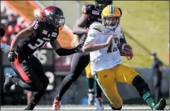  ?? CP PHOTO JEFF MCINTOSH ?? Edmonton Eskimos’ quarterbac­k Mike Reilly, right, runs with the ball under pressure by Calgary Stampeders’ Shaquille Richardson, left, during second half CFL football action in Calgary, Monday.