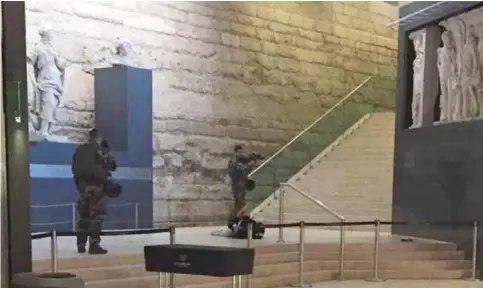  ?? — AP ?? PARIS: A man is seen on the floor as two soldiers guard him in the Louvre museum yesterday after an attack.