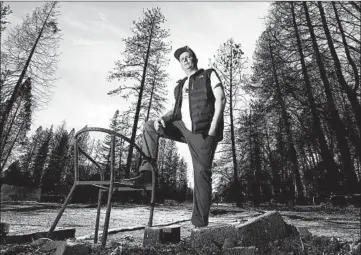  ?? RICH PEDRONCELL­I/AP ?? Camp Fire survivor Zachary Byrd poses where his home was located before it was destroyed by last year's wildfire.