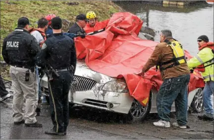  ?? PETE BANNAN — DIGITAL FIRST MEDIA ?? North Coventry police and members of the Phoenixvil­le Dive Team check a car that was found in the Schuylkill River just off the South Penn Street boat ramp in North Coventry Tuesday afternoon.