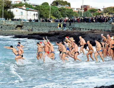  ??  ?? Circa 200 persone hanno partecipat­o, a Livorno, al tuffo di Capodanno, stavolta in memoria delle vittime dell’alluvione; sotto, il concertone al Piazzale Michelange­lo, a Firenze