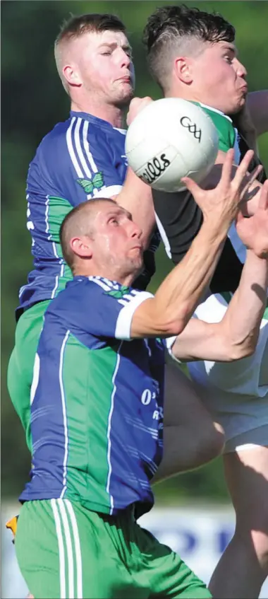  ??  ?? Ray Finnegan emerges with possession from a tussle with O Raghallaig­h’s Ruairi Moore and his Pat’s teammate Rory Duffy at The Grove on Sunday night. Picture: Ken Finegan