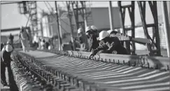  ?? PHOTO: BLOOMBERG ?? Workers fix steel rail track sections to concrete sleepers. The Free Trade Area will yield major economic benefits for the continent, says the writer.