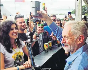  ??  ?? Corbyn delights young music fans by raising spirits at a Glastonbur­y bar