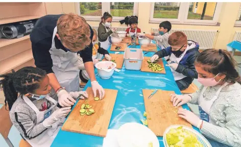  ?? FOTO: ARNULF STOFFEL ?? Kinder der Lindenschu­le in Repelen lernen mit entspreche­nder Hilfestell­ung den Umgang mit gesunden Lebensmitt­eln.