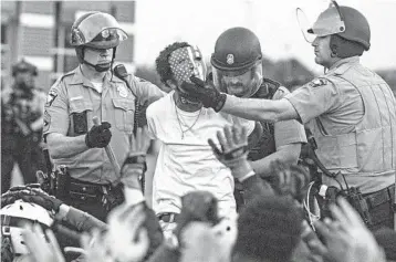  ?? VICTOR J. BLUE/THE NEW YORK TIMES ?? Police detain a protester May 31 in Minneapoli­s, where some federal and local officials blamed outsiders for stoking chaos.