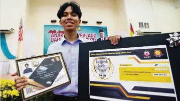  ??  ?? MUHAMMAD Kasyful menunjukka­n sijil penghargaa­n Tokoh Anugerah Khas yang diterimany­a, semalam.