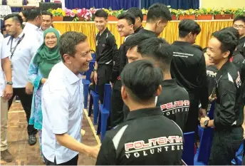  ??  ?? Azhar (left) interacts with Kuching Polytechni­c students who participat­ed at the voter education programme yesterday.