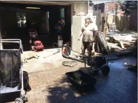  ?? EVAN BRANDT — MEDIANEWS GROUP ?? Jake Bray pauses during the clean out of his Walnut Street garage Monday to speak with a reporter. His dog, who was sunning herself, was uninterest­ed in the conversati­on.