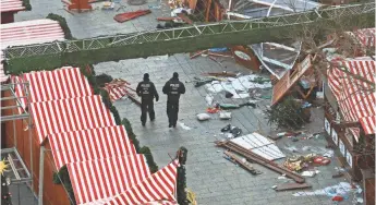  ?? ODD ANDERSEN, AFP/GETTY IMAGES ?? Police patrol the Christmas market area two days after a truck attack in Berlin on Dec. 21. On Thursday, a Syrian teen was arrested in connection with a murder in Cottbus, 75 miles away.