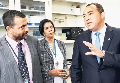  ?? FILE ?? Minister of Health Dr Christophe­r Tufton (right) chats with Dr Alison Nicholson (centre), head of Microbiolo­gy Department, and Chief Medical Officer Dr Winston De La Haye, during a tour of the Virology Lab at the University Hospital of the West Indies....